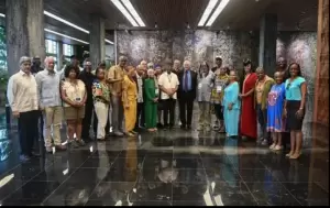 A group of people stands posed for a group photo in a large, modern indoor space with marble floors and artistic walls. - PsychDiscouse